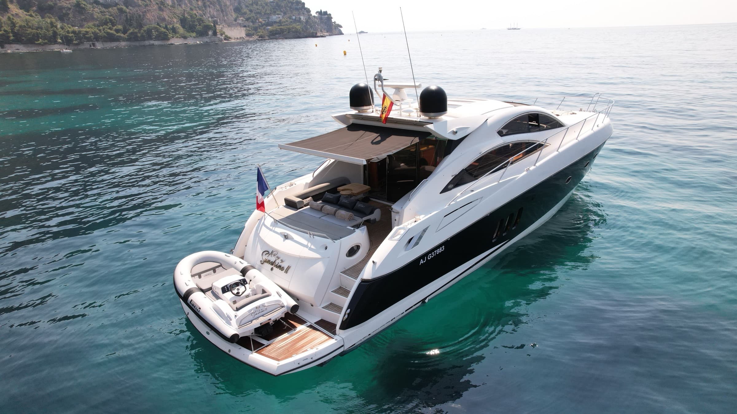 Le Sunseeker Predator 62 au mouillage dans une crique turquoise de la Côte d'Azur, vue aérienne de trois quarts