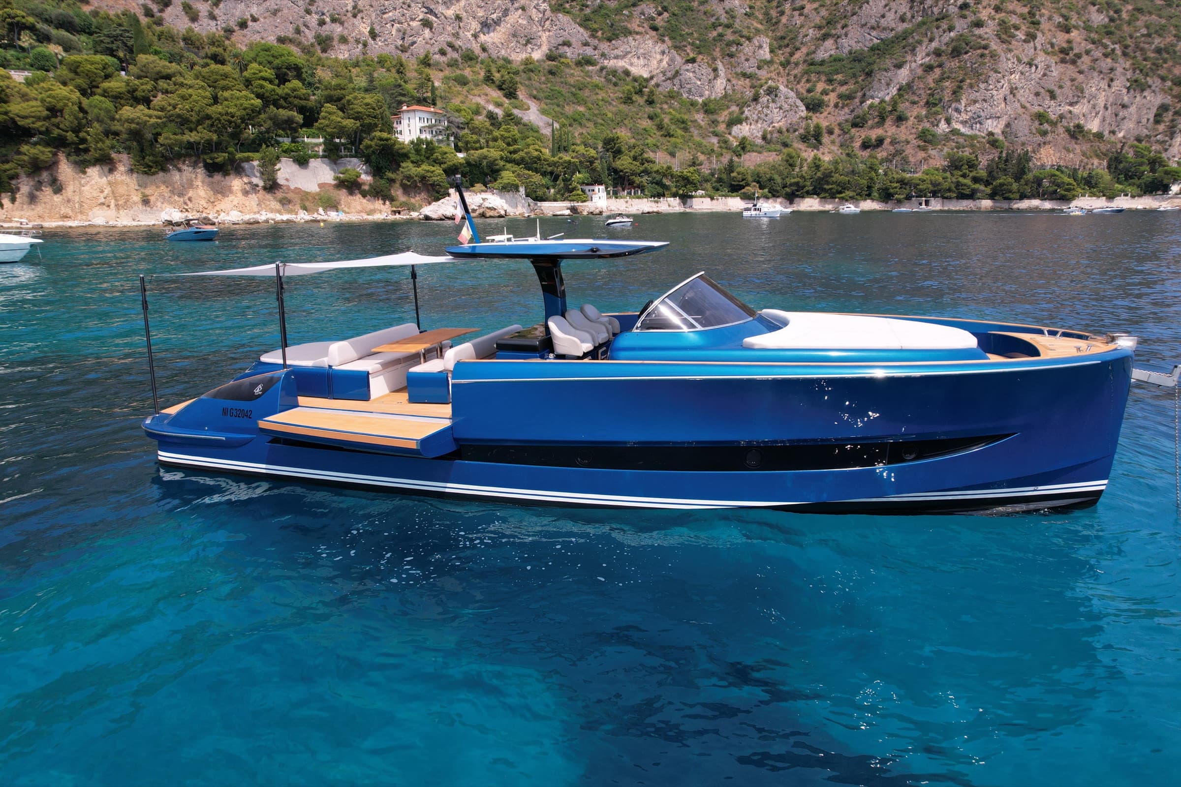 Le Solaris 48 Open à coque bleue au mouillage dans les eaux turquoise de la Côte d'Azur