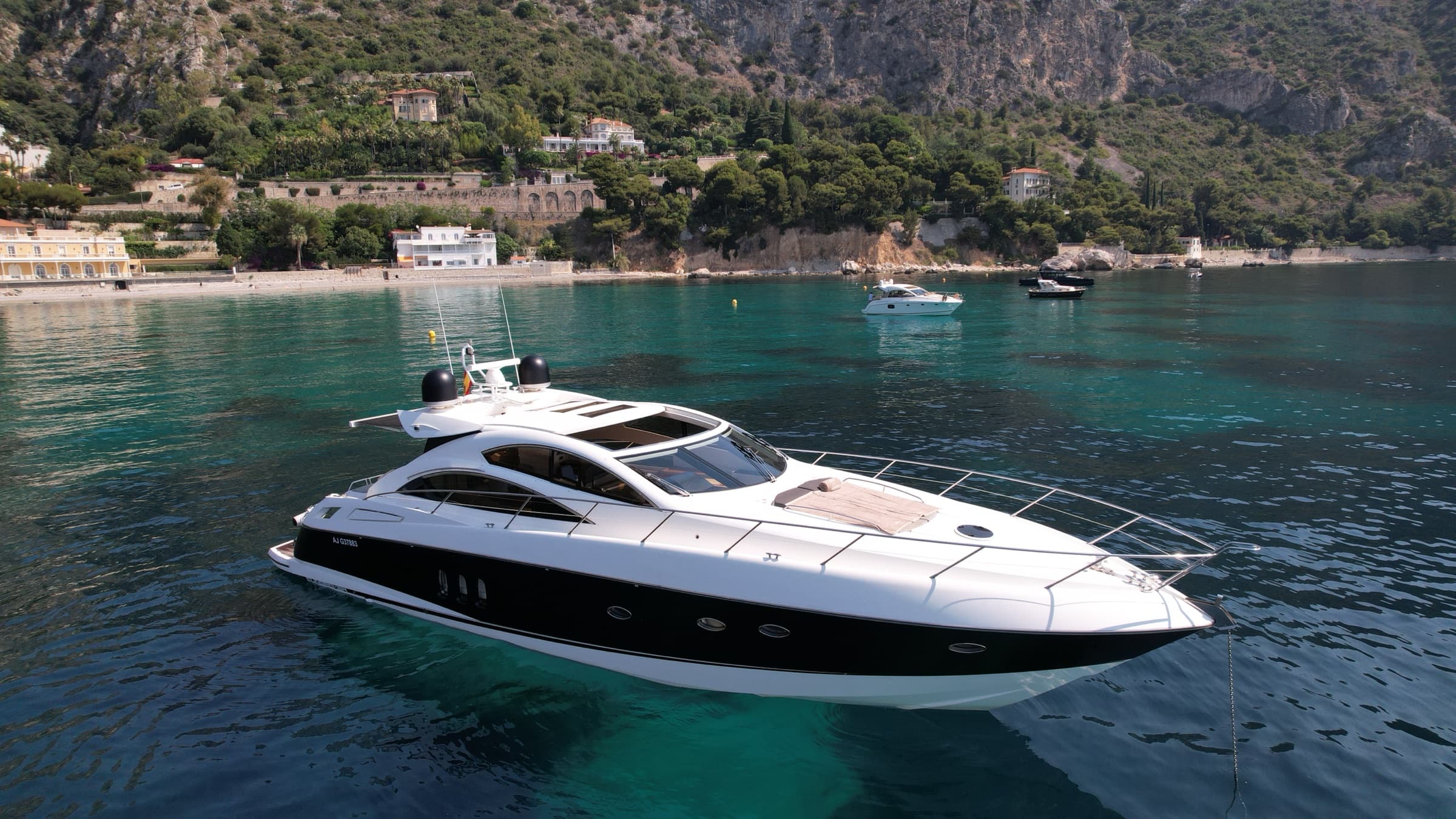 Le Sunseeker Predator 62 au mouillage face à une plage de la Côte d'Azur, vue aérienne de trois quarts avant
